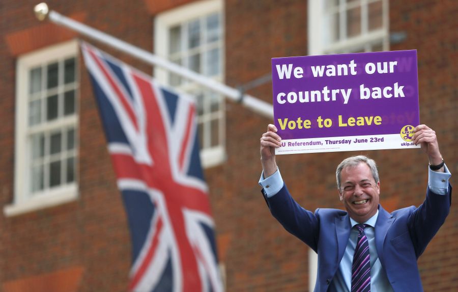 Leader of the United Kingdom Independence Party Nigel Farage holds a placard as he launches his party's EU referendum tour bus in London